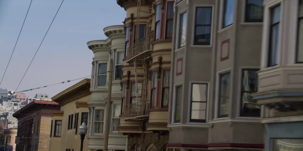 Homes and apartment buildings on a steep hill in a city on a sunny day