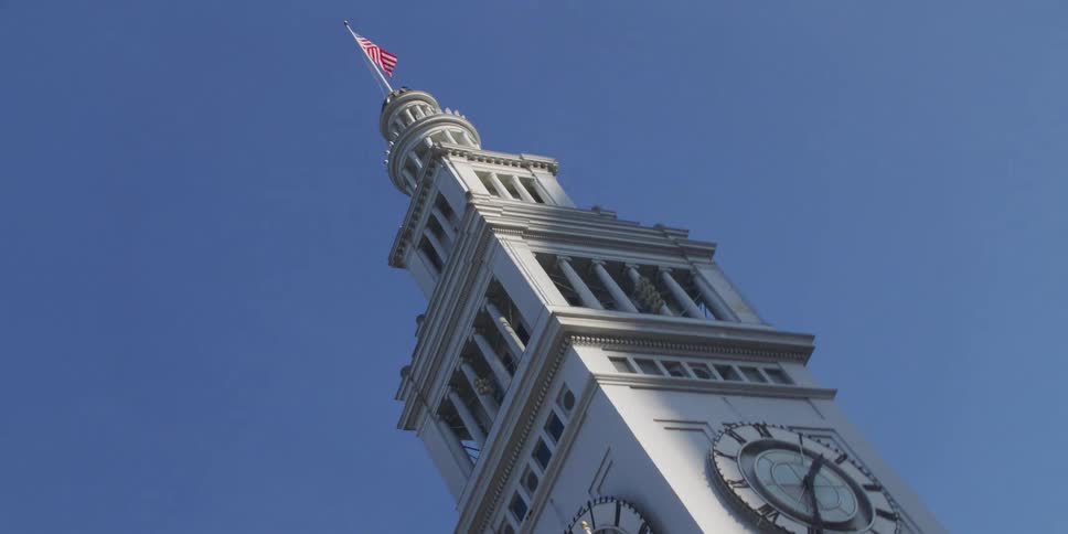 The american flag blows in the breeze atop the port of san francisco clock tower