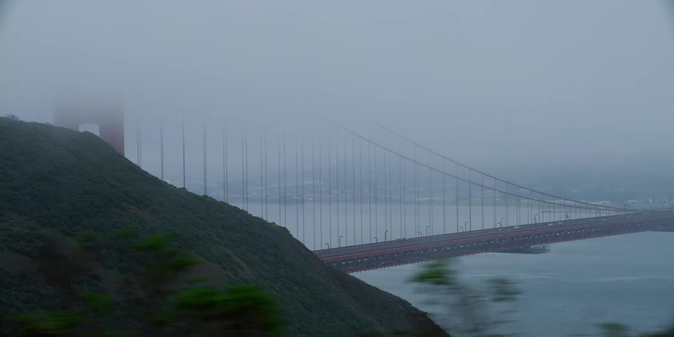 Cars driving across a bridge on a foggy day