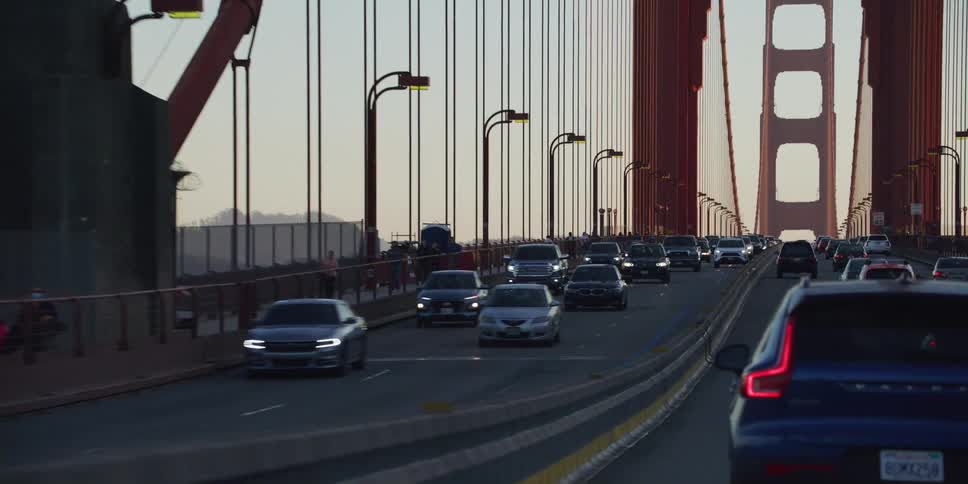 Cars cross golden gate bridge at dusk