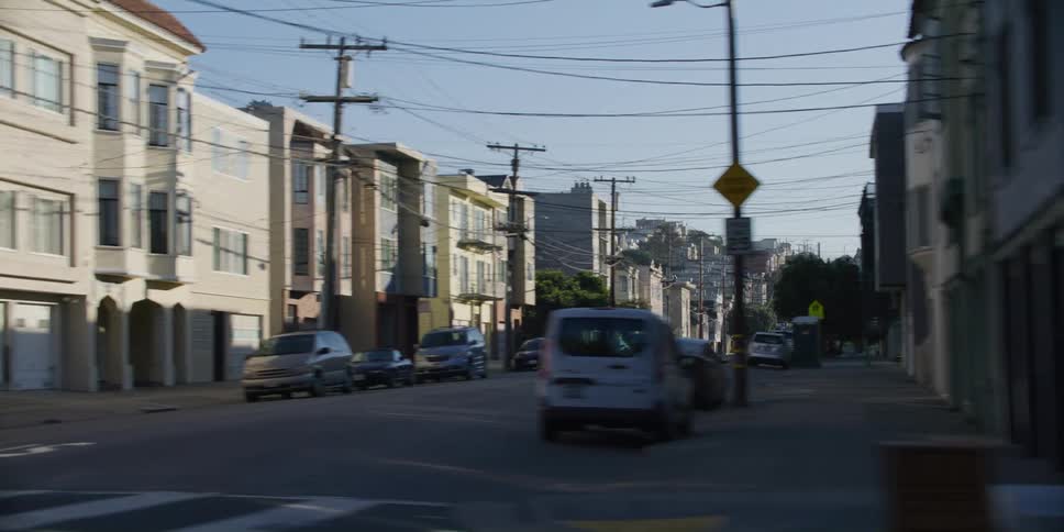 Inner city neighborhood with parked cars at a sunny day