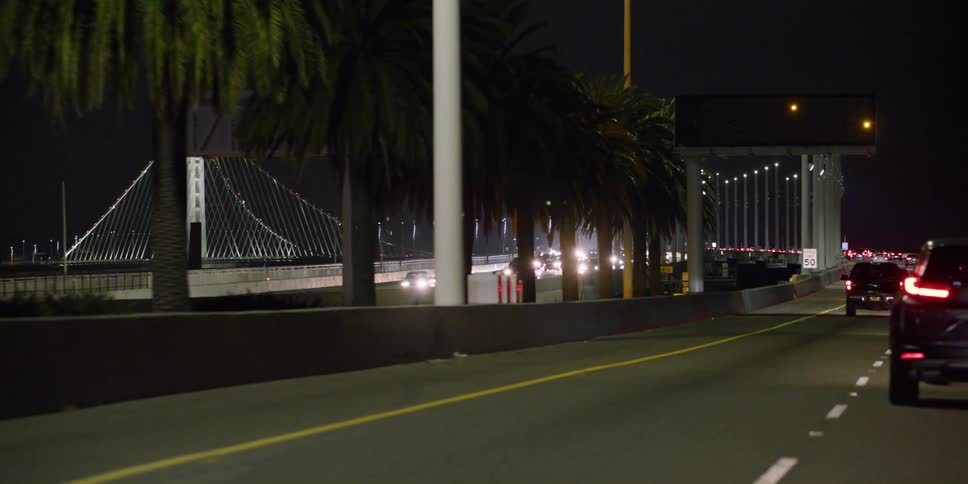 Cars are driving on an interstate at night