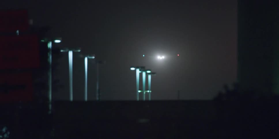 Airplane landing on an airport in the city at night