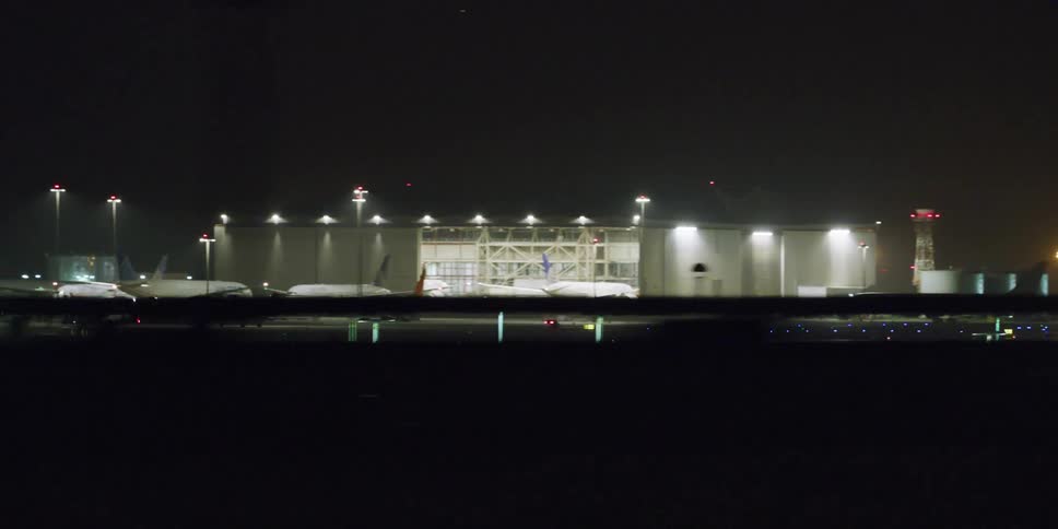 Airplanes are parked at an airport at night