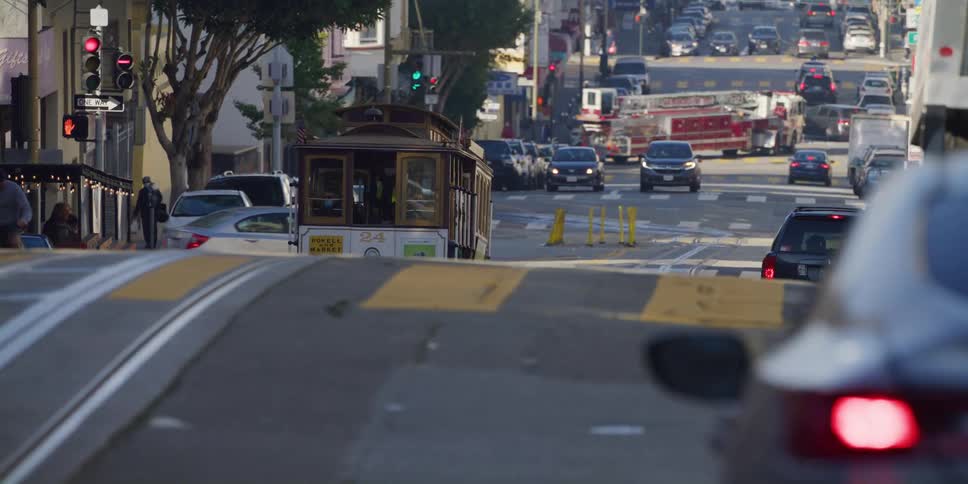 Heavy traffic including a streetcar and a firetruck drive through downtown