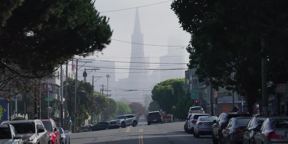 Pedestrians and cars are driving through a city