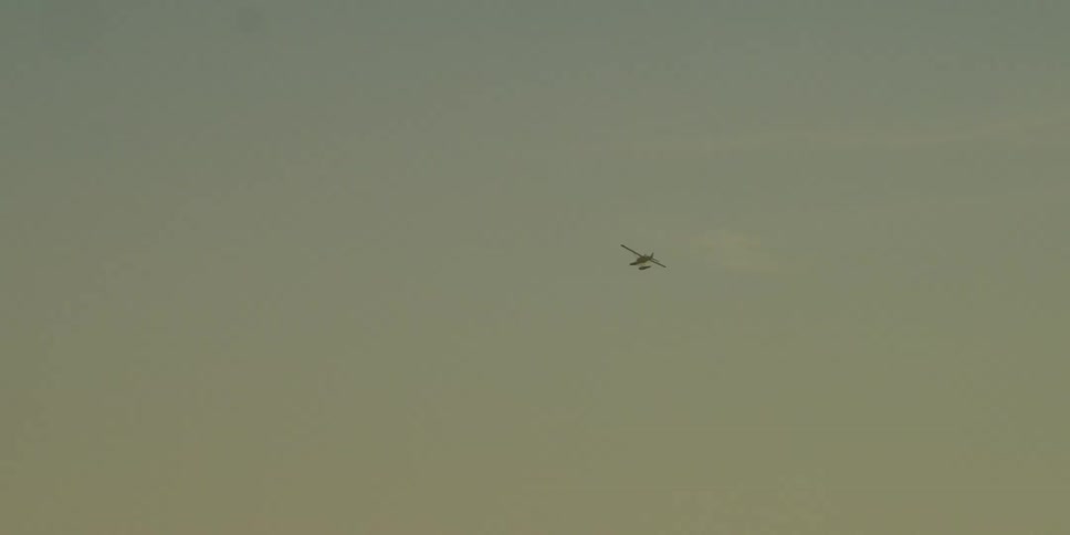 A plane flies through heavy fog