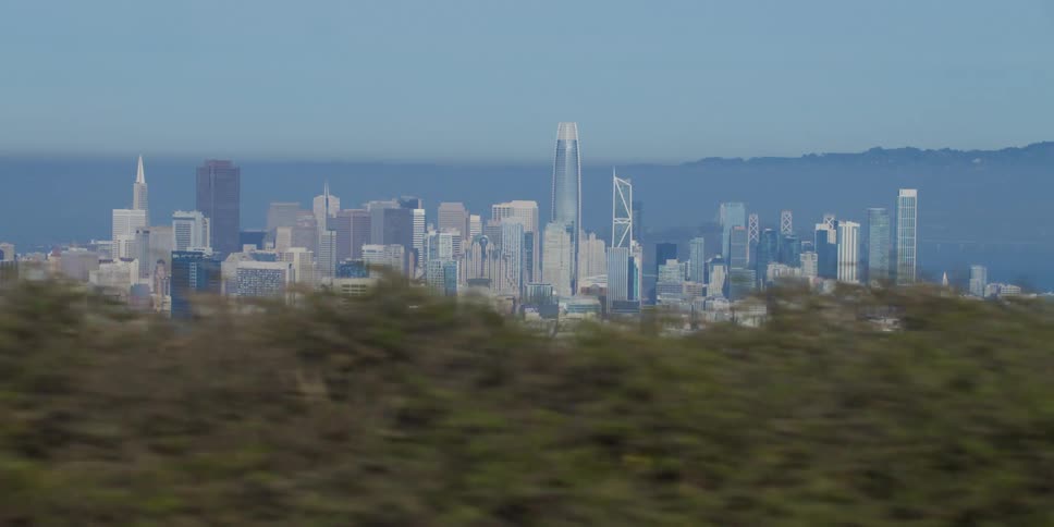 Fog covers city downtown sitting between vegetation covered hills