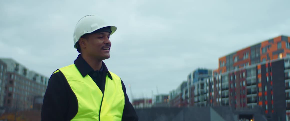 A construction worker waves and talks