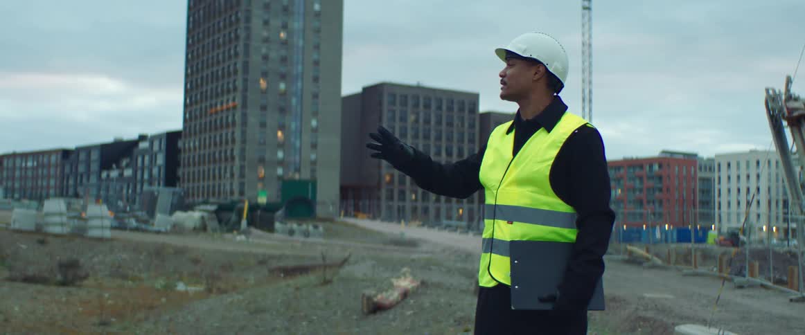 A construction worker talks and points