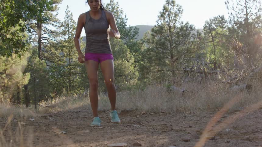 Woman running on a dirt trail in the woods