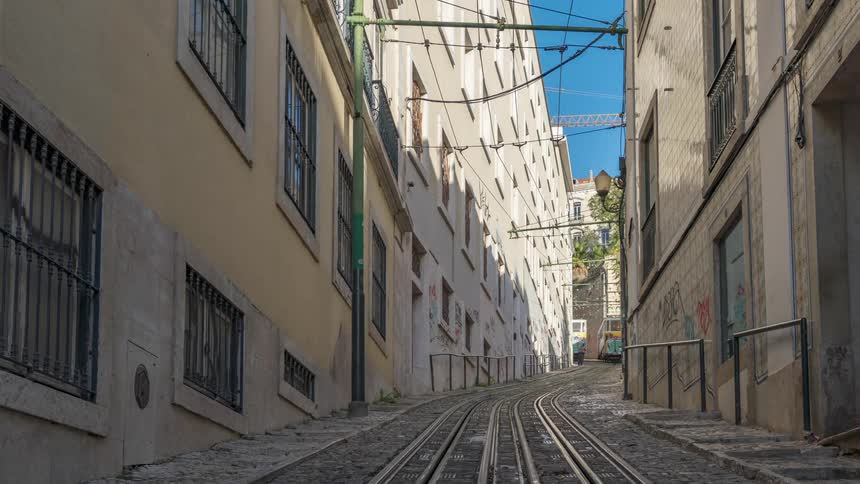Yellow tram on narrow street of alfama district in lisbon portugal