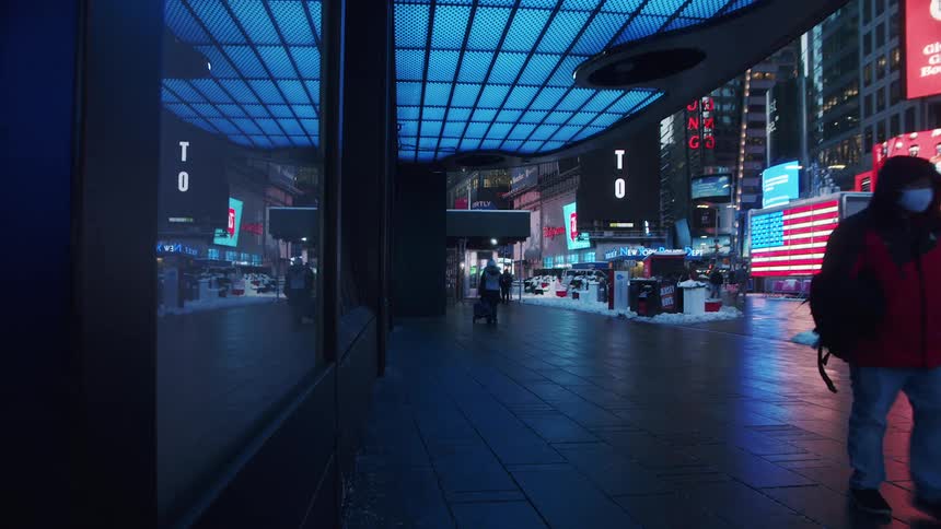 Pedestrians walk down the busy sidewalk