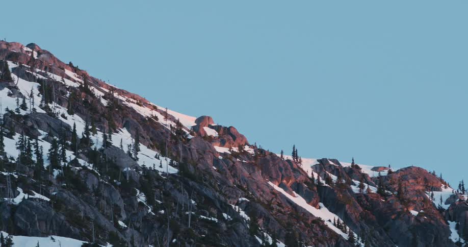 Snow and trees are covering the mountains