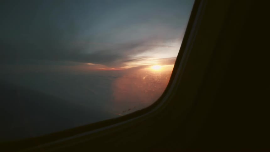 View of the sun setting from an airplane window