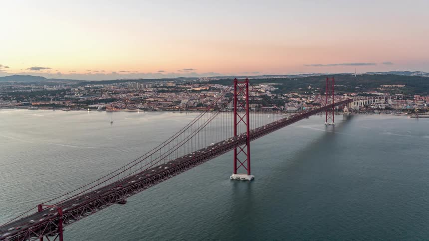 Heavy traffic passes across a bridge throughout the day and evening