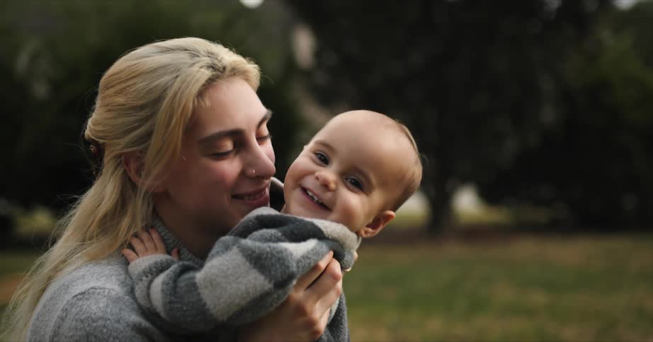 Baby happily running towards her mother and the mother holding and kissing the baby