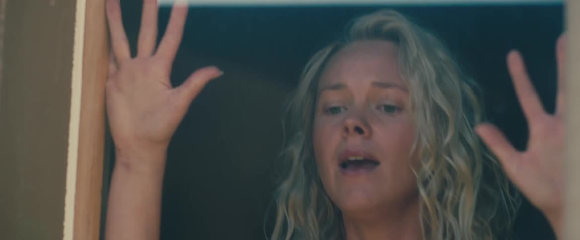 Blonde woman yells and hits window glass trying to get attention