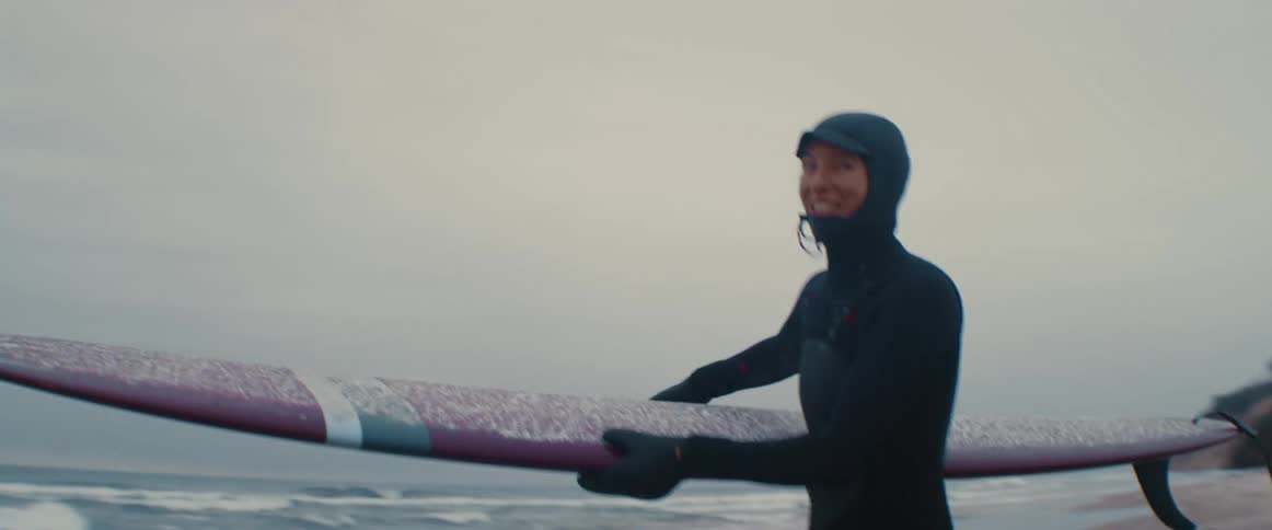 A man in a wet suit going to surf