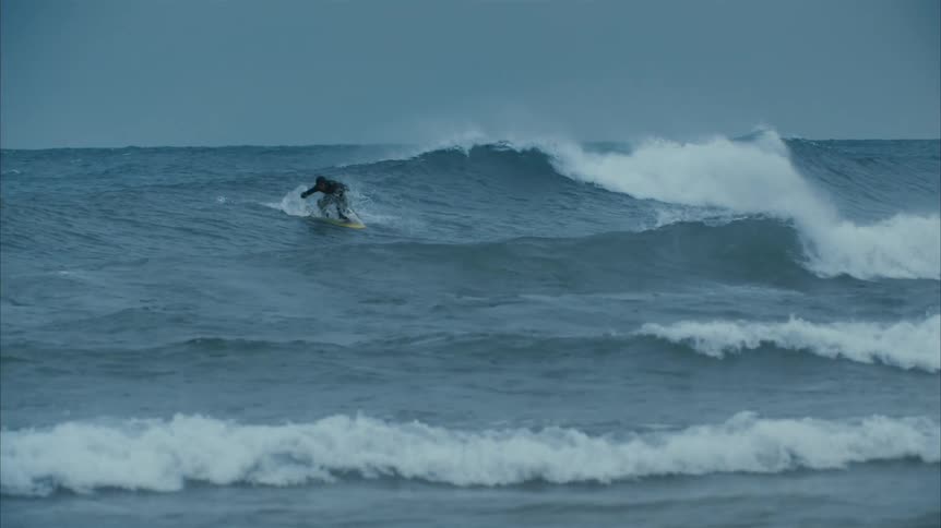 A man surfing in the winter