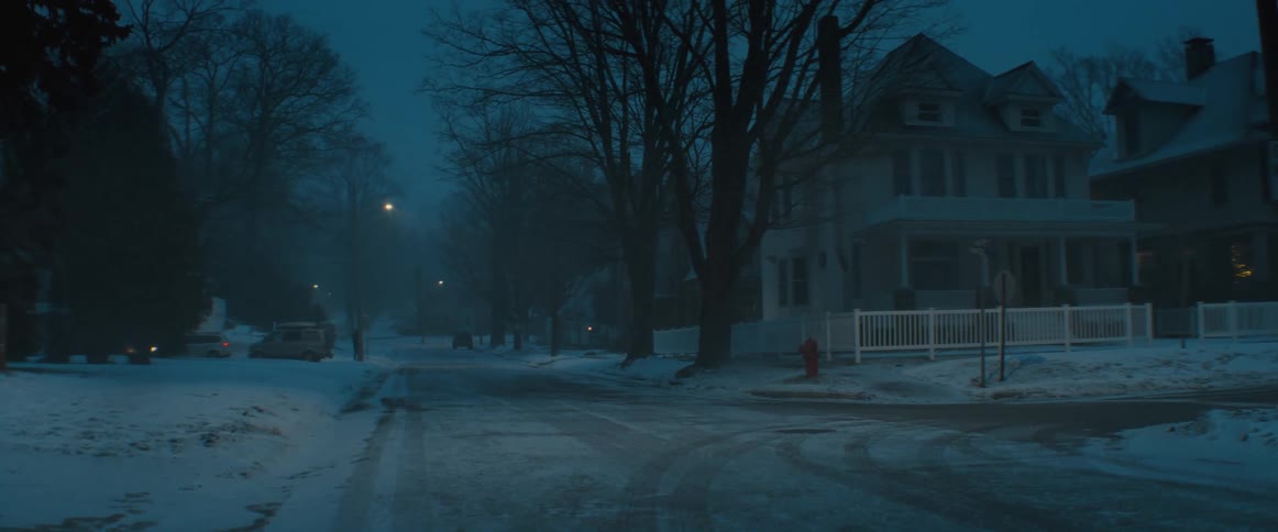 A view of a road in a neighborhood with snow