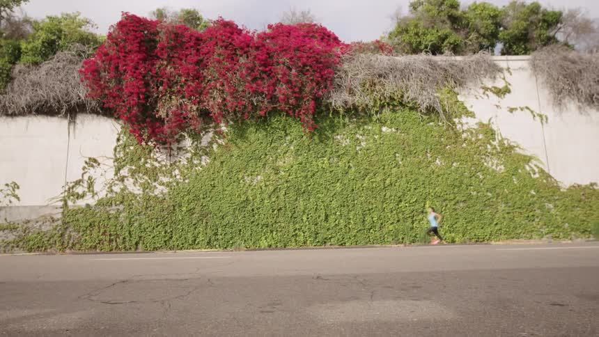 A car drives past as a woman runs down the road