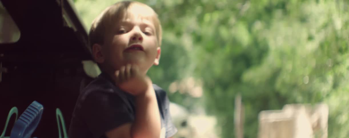 A toddler boy eats and fidgets