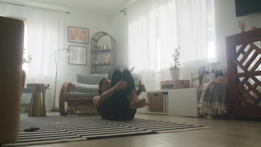 A man is exercising in his living room during the day