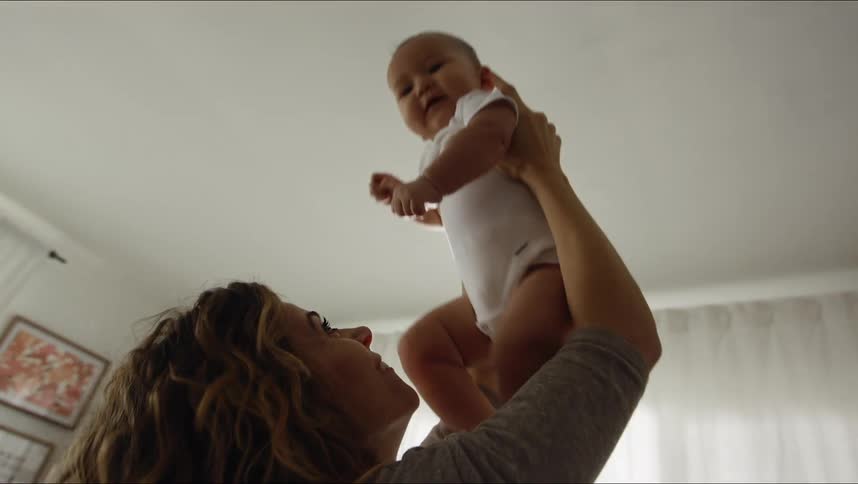 A mother kissing her baby in a room