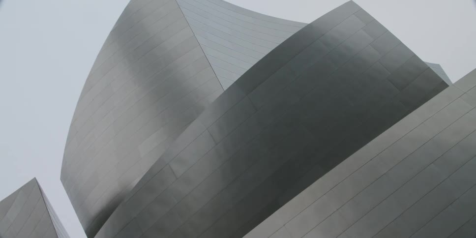 A modern building is designed with curved lines and minimal windows