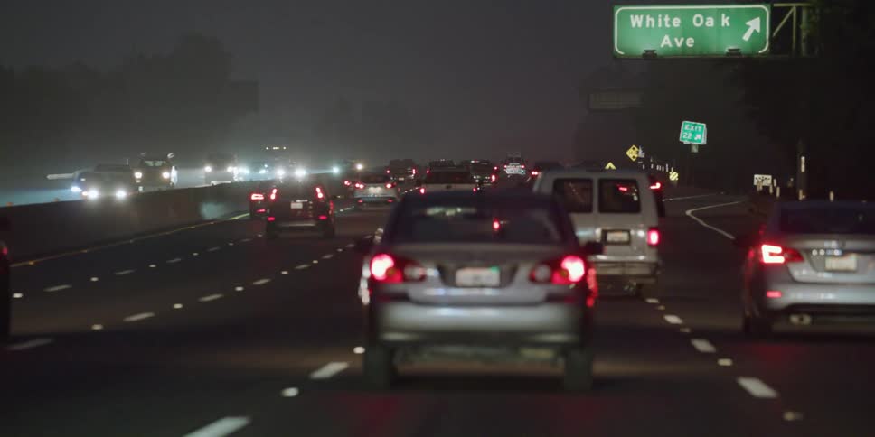 The traffic is moving at night on the highway