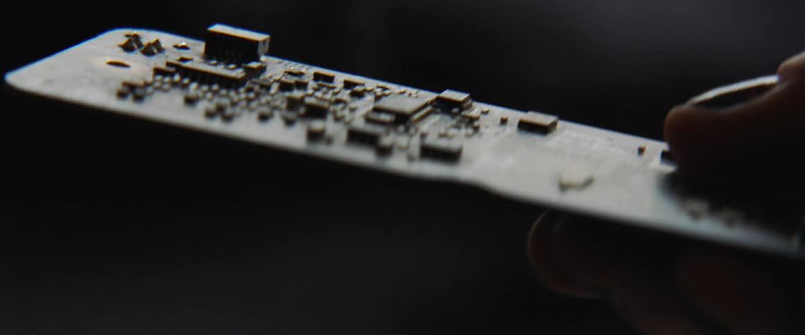 A person is holding a motherboard indoors