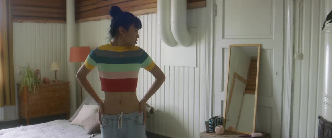 A woman is standing indoors and looking in a mirror