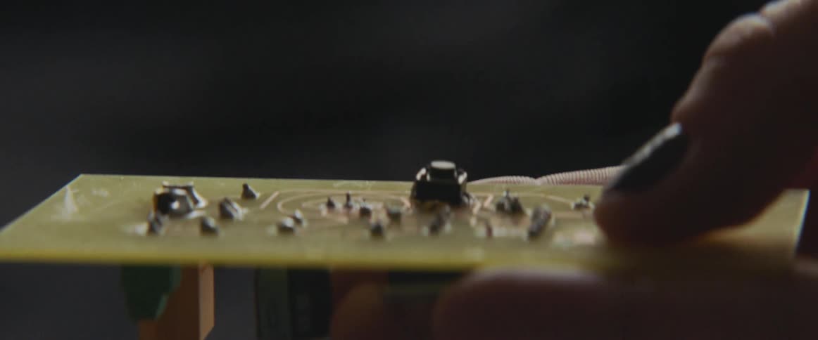 Rectangular circuitry board held in a hand