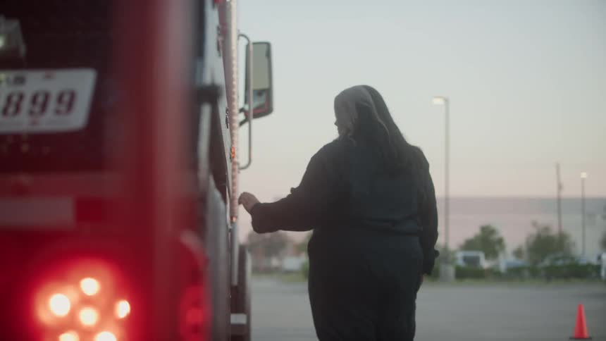 A view of a woman walking next to a shipping truck