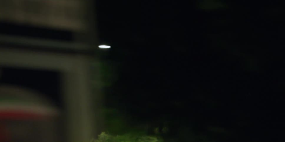 Two structures light up the night sky atop the hill
