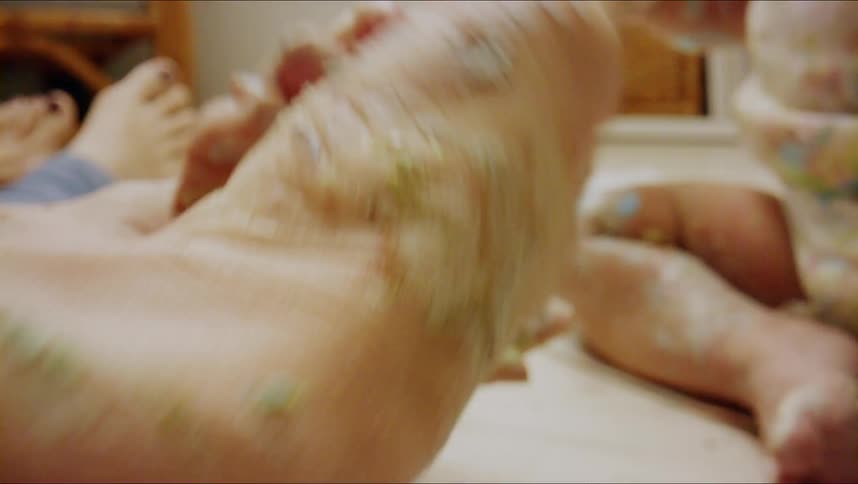 Closeup of finger scooping pink paint from small bowl