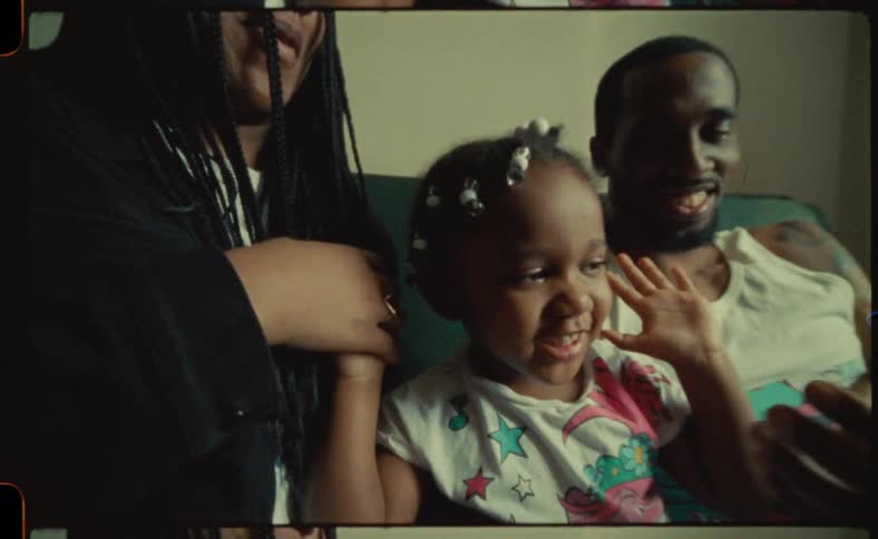 Mother father and baby daughter sitting at the couch in the living room interacting and laughing together