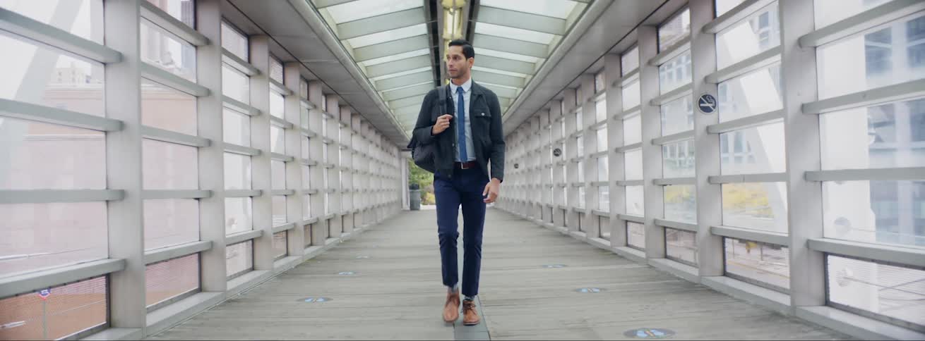 A man is walking through the building overpass