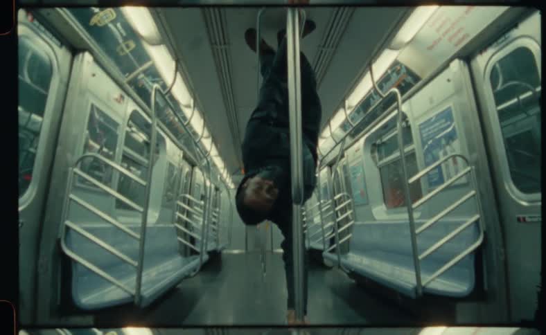 A man performs dance moves inside a subway car