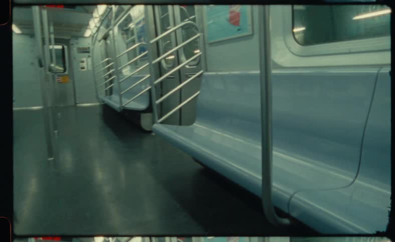 The inside of an empty subway train car as it travels