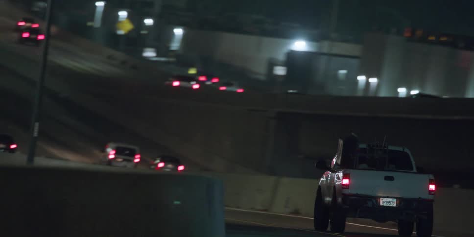 Vehicles driving down a freeway at night