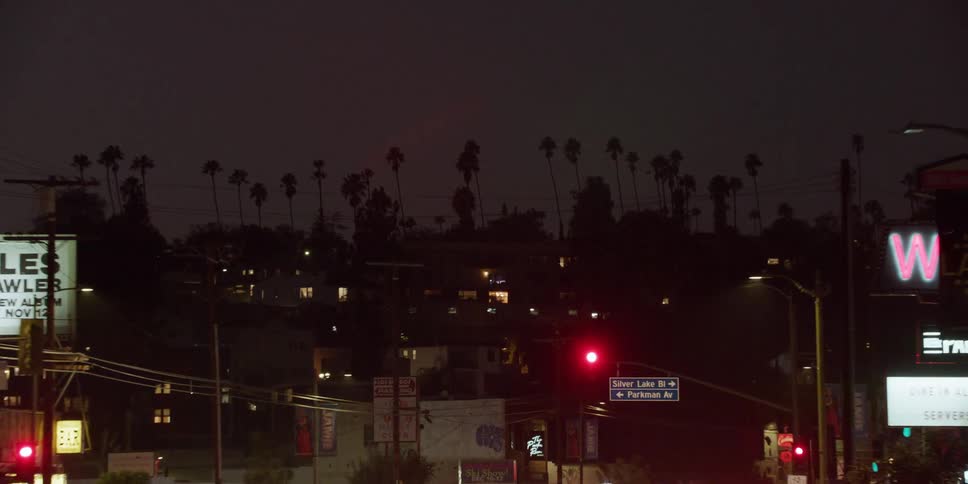 Cars are driving through a downtown city at night
