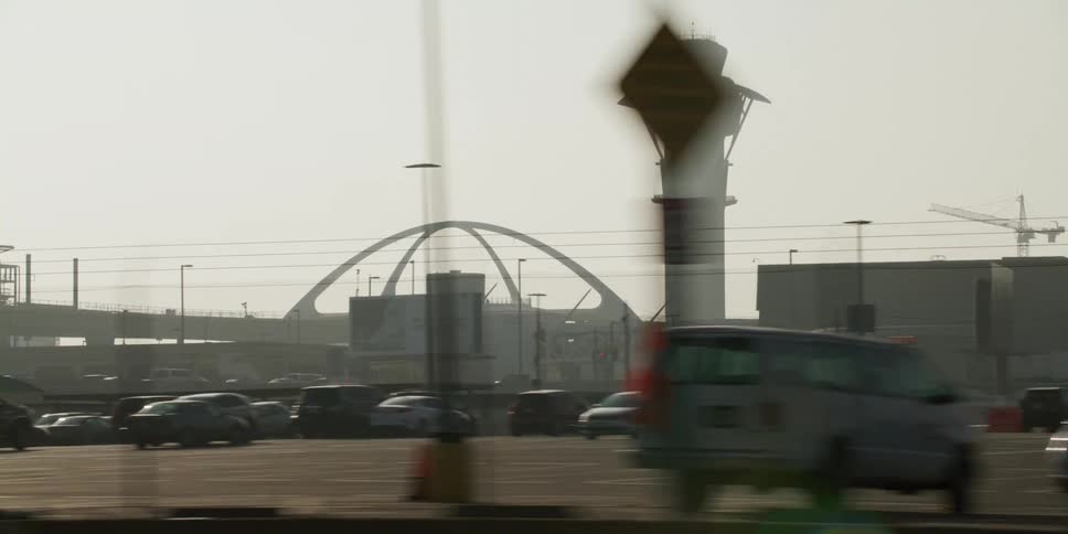 Airport control tower looms over a parking lot