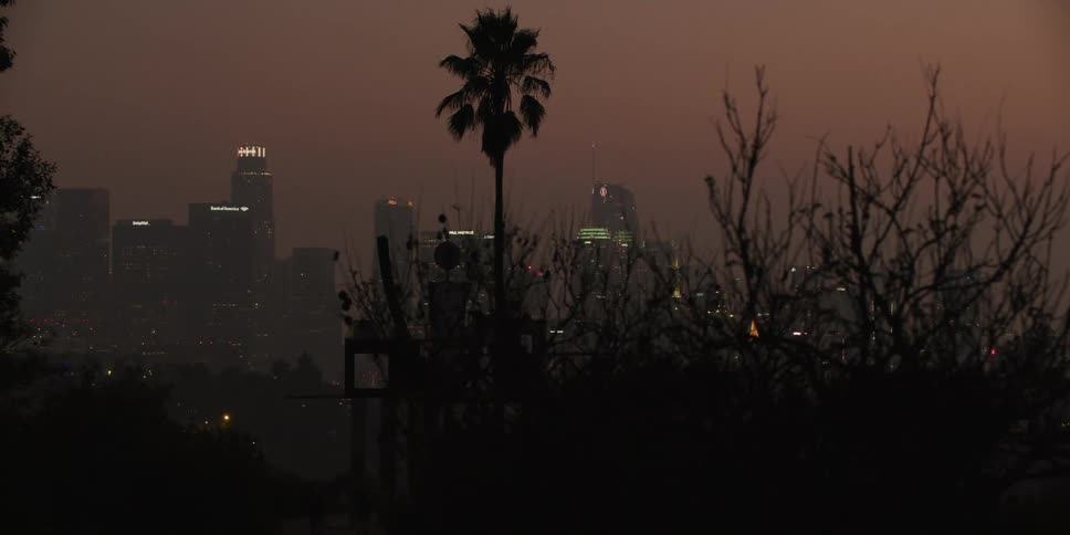 Distant illuminated high rise buildings at sunset