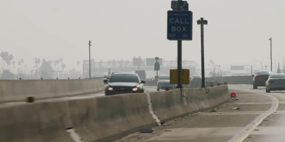 Vehicle drives on dual carriageway in foggy city