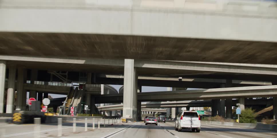 Traveling along the highway and passing under several layers of overpasses during the daytime