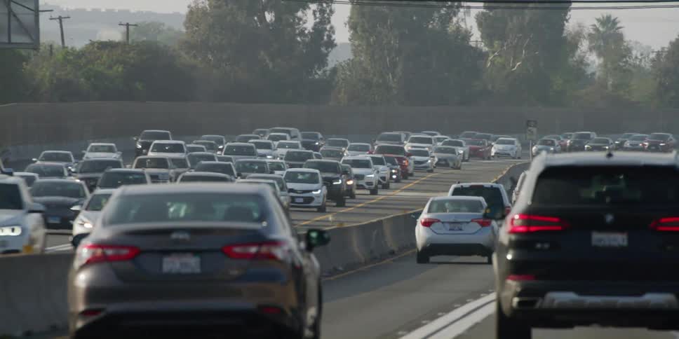 Automobiles travel on a highway in busy traffic