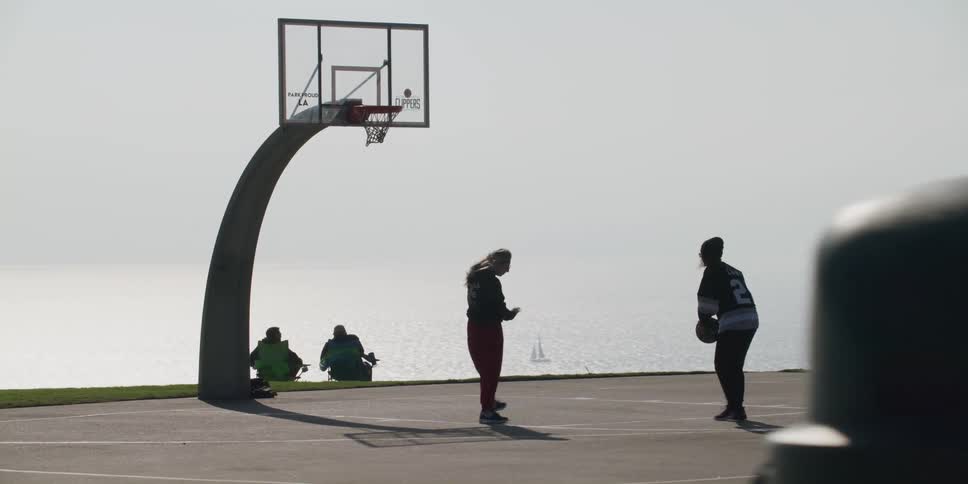 People are playing basketball near a body of water