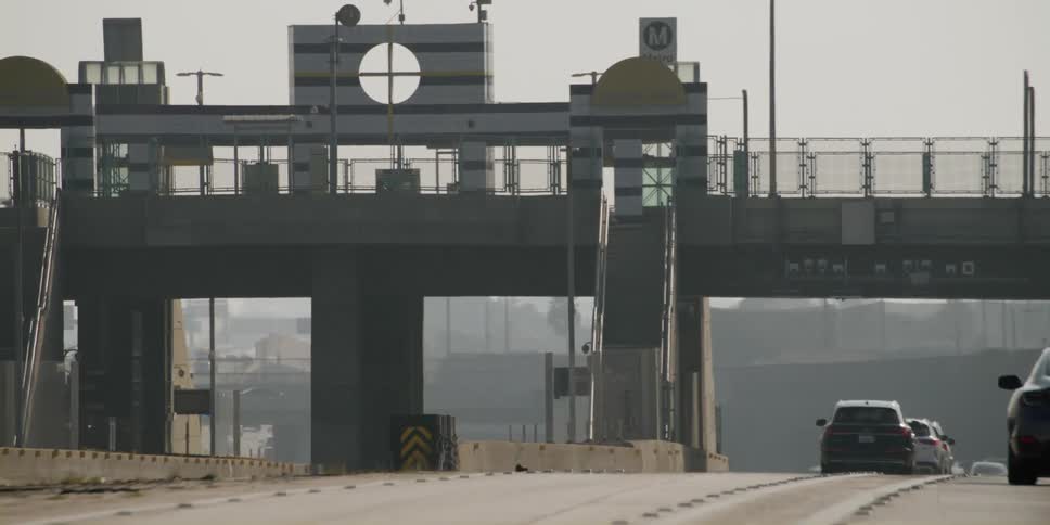 Vehicles drive on a multi lane highway under an overpass
